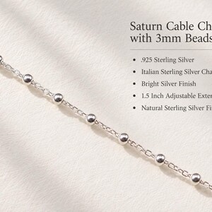 May include: A Saturn cable chain with 3mm beads made of .925 sterling silver. The chain features a bright silver finish and a 1.5 inch adjustable extender. The text reads: Saturn Cable Chain with 3mm Beads, .925 Sterling Silver, Italian Sterling Silver Chain, Bright Silver Finish, 1.5 Inch Adjustable Extender, Natural Sterling Silver Finish.