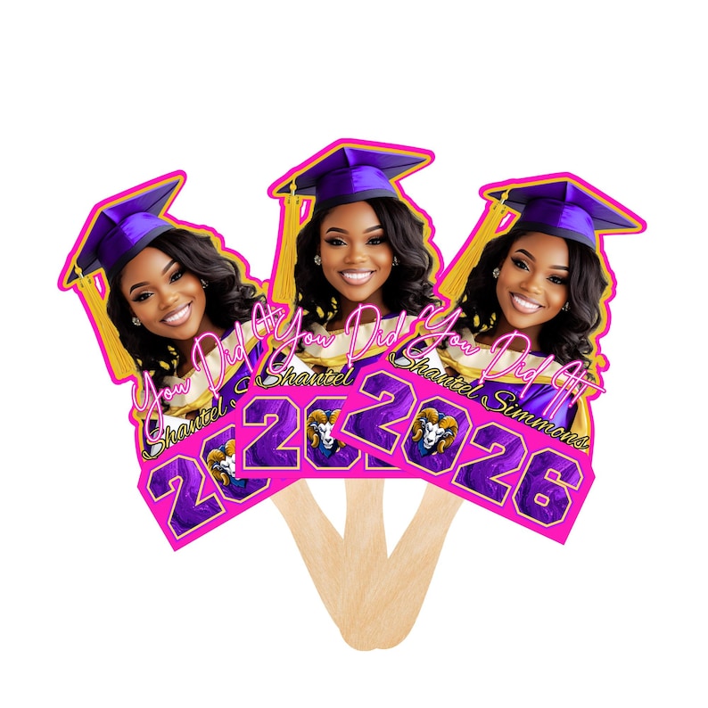 May include: Three graduation fan favors featuring a smiling woman wearing a purple graduation cap with gold tassels. The fans have the text "You Did It Shantel 2026" in pink and purple.