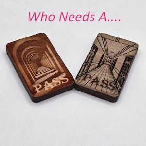 May include: Two rectangular wooden passes with engraved designs. One features a tunnel, the other a hallway, both with the word "PASS" at the bottom. The text "Who Needs A..." is above the passes.