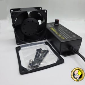 May include: A black cooling fan with a square frame, a black power adapter with a dial, and a small bag of screws and nuts. The power adapter has the text "ADAPTER POWER" and other technical details.