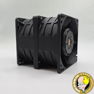 May include: A pair of black, square-shaped fans with multiple blades. The fans are made of a dark plastic material and have mounting holes on the corners. The image is taken on a white surface.