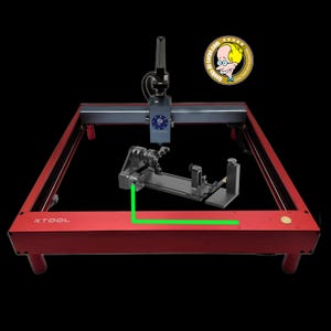 May include: A red XTOOL laser engraving machine with a black and gray laser head and a black accessory. The machine has a rectangular frame and is set against a black background. A cartoon logo is in the upper right corner.
