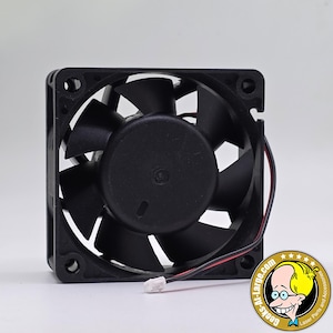 May include: A black square fan with a central hub and curved blades. The fan has a wire with a white connector. The image includes a logo with the text "Geeks-At-Large.com Laser Parts and Accessories".