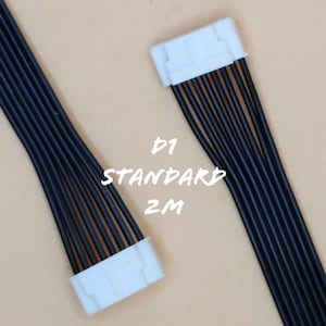 May include: Two black wire harnesses with white connectors. The text "D1 STANDARD 2M" is printed on the background. The wires are bundled together and appear to be for electronic devices.