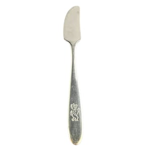 May include: A silver butter knife with a cartoon bear design on the handle.