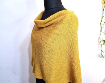Peut inclure: Un poncho tricoté jaune moutarde doté d'un col bénitier drapé. Le vêtement est confectionné dans un fil texturé avec un motif de tricot uniforme, tombant librement sur les épaules et le torse avec un ourlet droit et des côtés ouverts.
