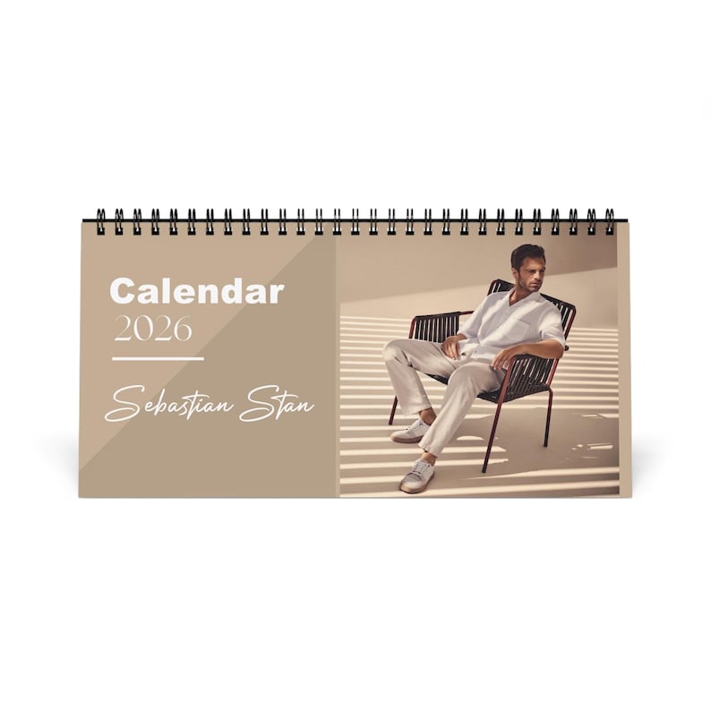 May include: A spiral-bound desk calendar for 2026 featuring a photograph of Sebastian Stan. The calendar has a neutral color scheme with the word "Calendar" and the year "2026" printed in white. The name "Sebastian Stan" is written in cursive.