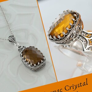 May include: A silver necklace and ring set with a cognac crystal quartz stone. The stone is a light brown color and has a faceted cut. The necklace and ring have intricate filigree designs.