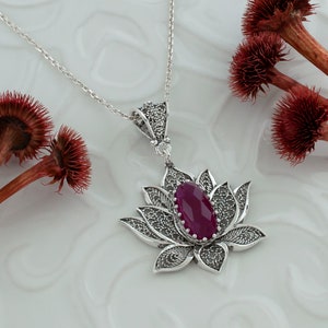 Op de afbeelding: Een zilveren filigrain lotusbloem hanger ketting met een dieproze edelsteen in het midden.