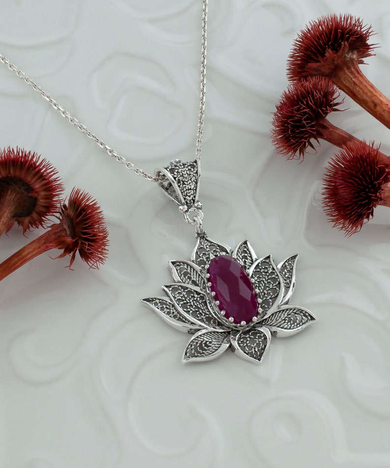 Op de afbeelding: Een zilveren filigrain lotusbloem hanger ketting met een dieproze edelsteen in het midden.