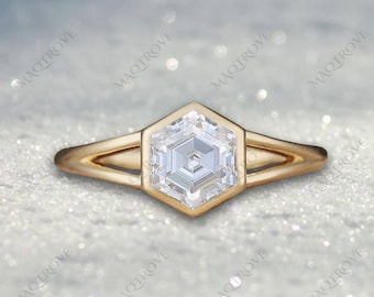 May include: A gold ring with a hexagonal shaped diamond. The diamond has a unique cut with many facets.