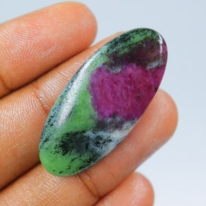 Puede incluir: Cabujón ovalado de piedra preciosa verde, rosa y blanca con una superficie lisa y pulida.