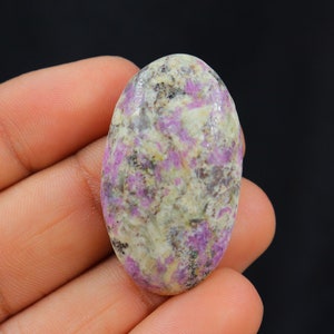 Peut inclure: Pierre précieuse en cabochon de forme ovale avec une base blanche et des tourbillons roses et gris.