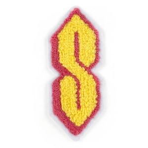 May include: A yellow felt letter S in a red outline, with a white outline around the red outline. The letter is in a stylized font.