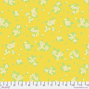 May include: Yellow fabric with a repeating pattern of small white flowers with pink centers and light green leaves. The fabric has a ruler along the bottom edge, with the text "Free Spirit" and "freespiritfabrics.com".