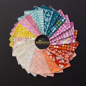 May include: A circular arrangement of fabric squares in various colors, including pink, yellow, teal, and orange, with white patterns. The center features the text "PAPER CUTS 2" and "RASHIDA COLEMAN-HALE" on a black circle. The background is black.