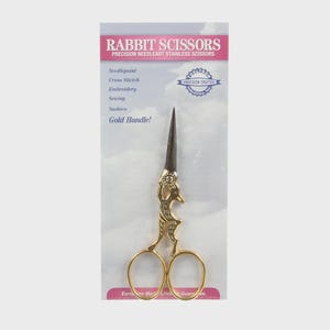 May include: Gold-handled Rabbit Scissors for needlepoint, cross stitch, embroidery, sewing, and sashiko. The scissors have a gold handle and stainless steel blades. The packaging reads "Rabbit Scissors" and "Precision Needleart Stainless Scissors."