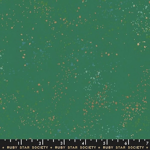 May include: Green fabric with a speckled pattern of small blue, orange, and green dots. The fabric has a ruler with markings in inches and the text "RUBY STAR SOCIETY" printed on it.