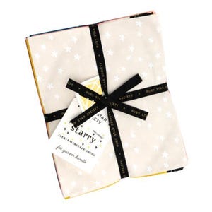 May include: A fat quarter bundle featuring a cream-colored fabric with white stars. The bundle is tied with a black ribbon that reads "RUBY STAR SOCIETY." A tag reads "Starry" and "fat quarter bundle."