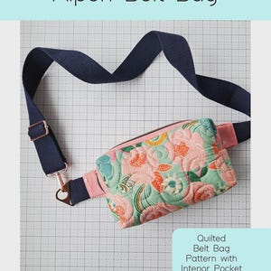 May include: Quilted Alpen belt bag with a floral pattern in pink, teal, and orange. The bag has a navy blue adjustable strap and a pink belt loop. The text "Alpen Belt Bag" is at the top. The text "Quilted Belt Bag Pattern with Interior Pocket" is on the right.