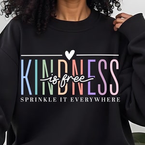 May include: Black sweatshirt with a rainbow colored graphic that says "KINDNESS is free" and "SPRINKLE IT EVERYWHERE" in white text.