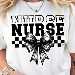 Op de afbeelding: Een wit T-shirt met een zwart grafisch ontwerp met de tekst "NITRO NURSE" met een zwart-wit geruit patroon en een zwarte strik.