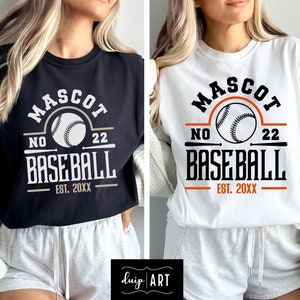 May include: Two women wearing white and black t-shirts with a baseball graphic and the text "MASCOT NO 22 BASEBALL EST. 20XX".