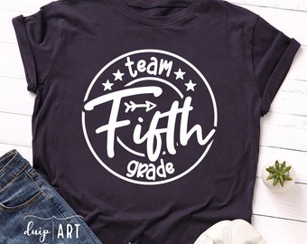 May include: A dark purple t-shirt with a white circle design that says "Team Fifth Grade" with a white arrow pointing to the right.