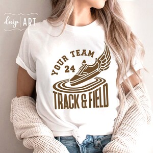 May include: White t-shirt with a brown graphic of a running shoe with wings and the text "Your Team 24 Track & Field"