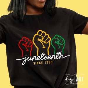 Peut inclure: T-shirt noir avec trois poings levés en rouge, jaune et vert, et le texte "Juneteenth Since 1865".