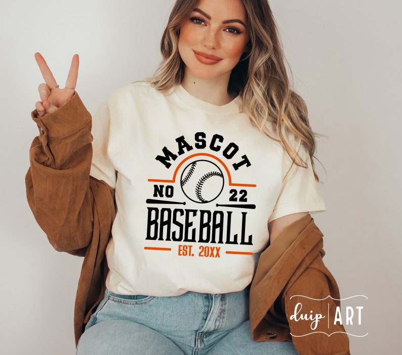 May include: White t-shirt with a black and orange baseball graphic. The graphic says "Mascot No 22 Baseball Est. 20XX".