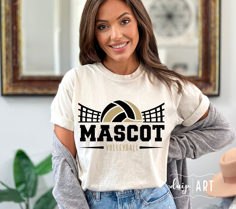 May include: A white t-shirt with a black and gold volleyball graphic and the text "MASCOT VOLLEYBALL".