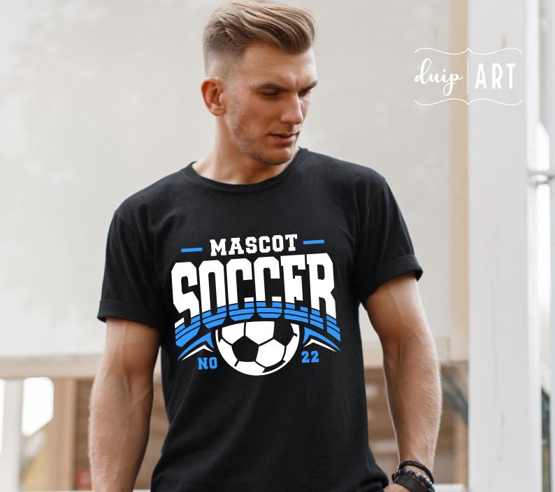Pu&ograve; includere: Maglietta nera con un design grafico bianco che dice "MASCOT SOCCER" con un pallone da calcio blu e bianco al centro. I numeri "NO 22" sono su entrambi i lati del pallone.