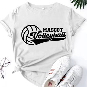 May include: White t-shirt with a black volleyball graphic and the text "Mascot Volleyball".