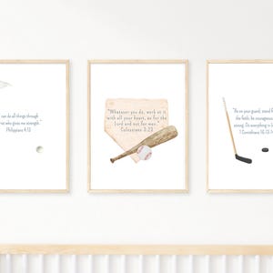 May include: Set of three framed prints with watercolor illustrations of sports equipment and Bible verses. Includes a golf flag, baseball bat and ball, and hockey stick and puck. Each print has a light wood frame.