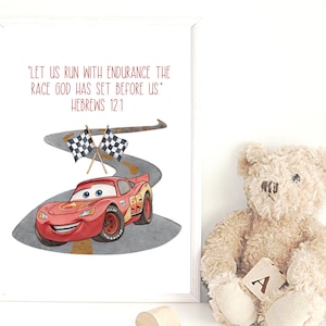May include: A framed print featuring a red cartoon race car on a winding road, with checkered flags. The text reads "LET US RUN WITH ENDURANCE THE RACE GOD HAS SET BEFORE US" HEBREWS 12:1. A teddy bear sits to the right.