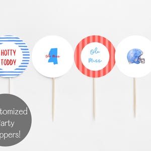 May include: Four white, round party toppers on wooden sticks. One has blue and white stripes with "Hotty Toddy" in red. Another features a blue outline of Mississippi. The third has red stripes with "Ole Miss" in blue. The last has a blue football helmet.