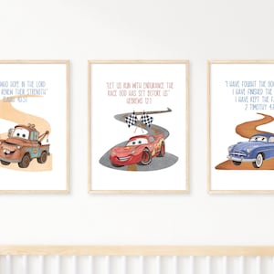 May include: Three framed art prints with cartoon cars and inspirational quotes. The prints show a tow truck, a red race car, and a blue classic car, each on a winding road, suitable for a child's room.