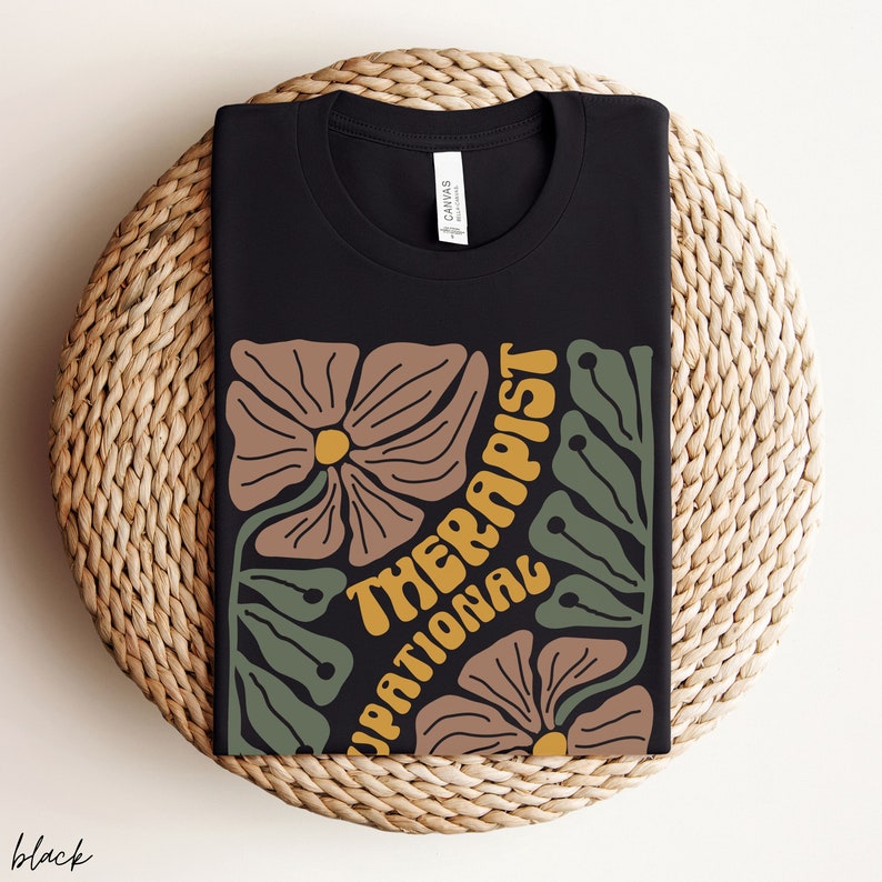 May include: Black t-shirt with a floral design and the text "Occupational Therapist" in yellow.