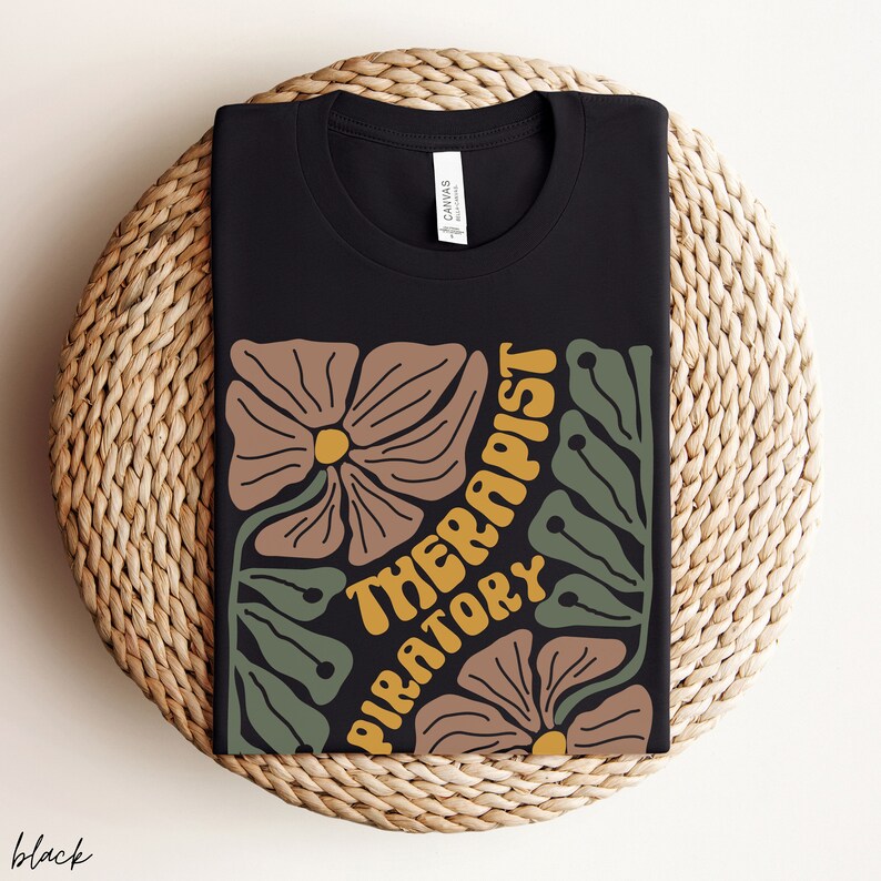 May include: Black t-shirt with a floral design and the text "Respiratory Therapist" in yellow.