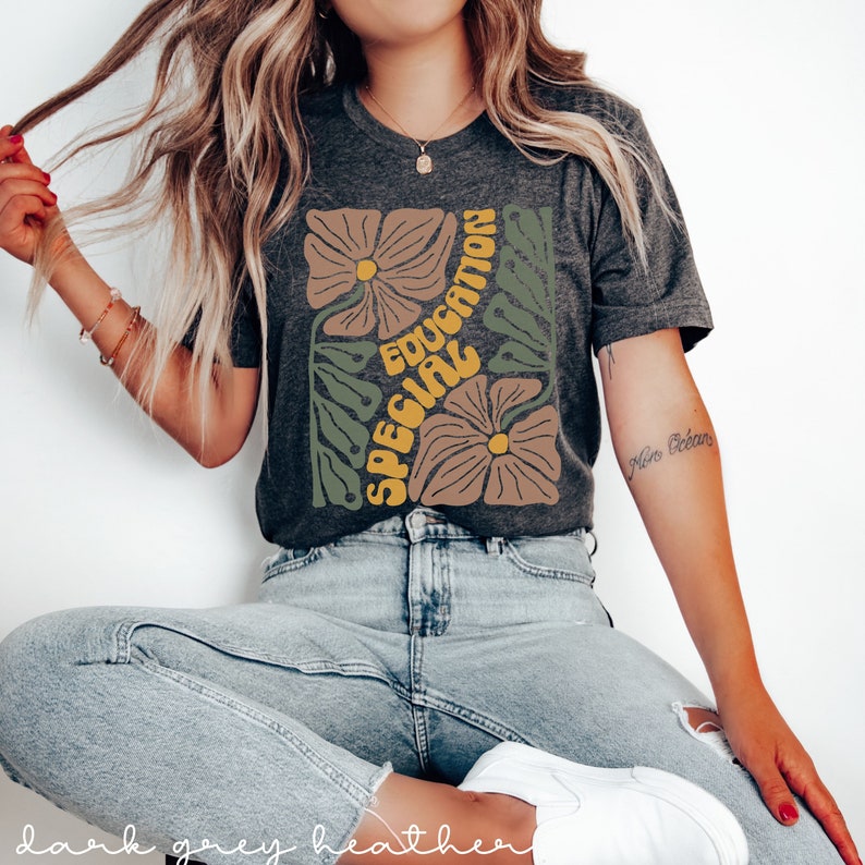 May include: A dark grey heather t-shirt with a floral design and the text "Special Education" in yellow and brown letters.