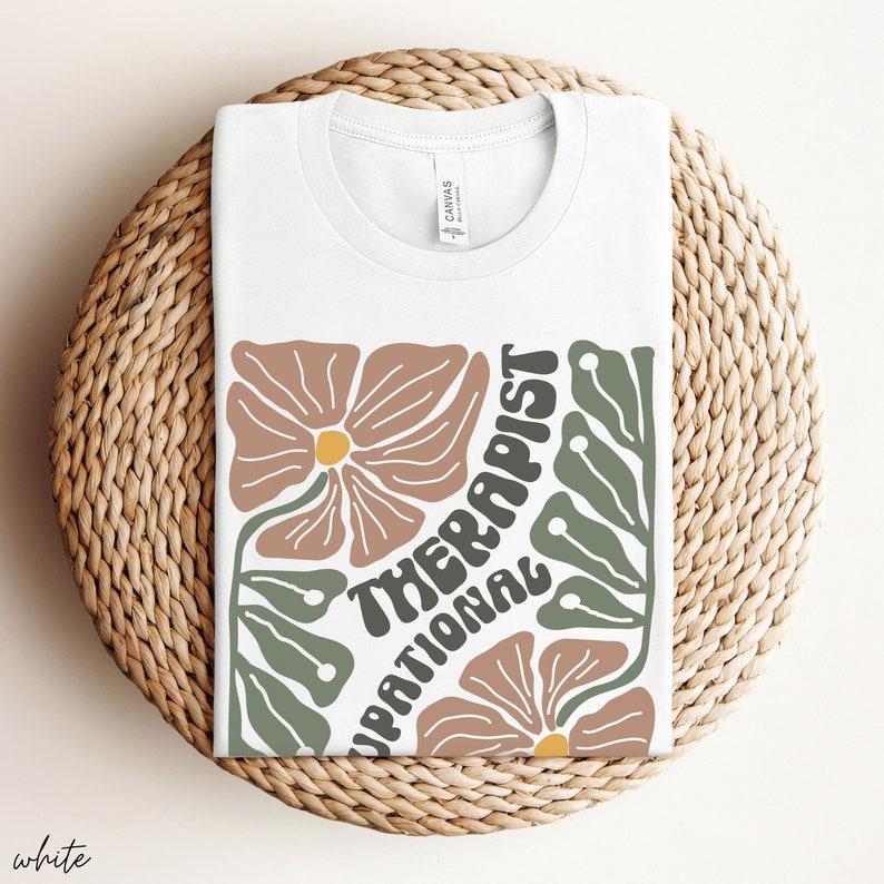 May include: White t-shirt with a floral design and the text "Occupational Therapist" in a retro font.