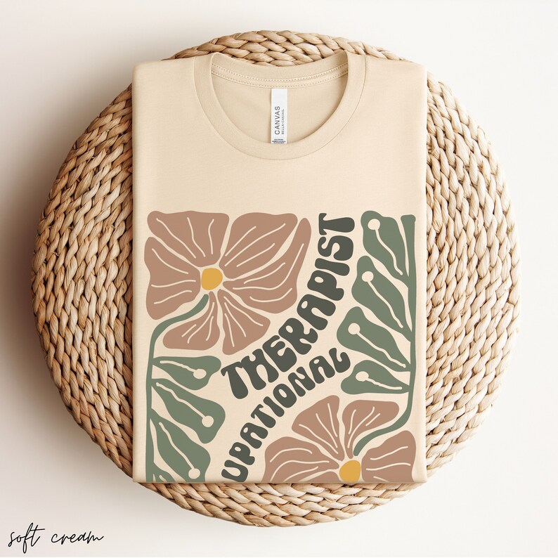 May include: A beige t-shirt with a floral design and the text "Motivational Therapist" in a retro font.