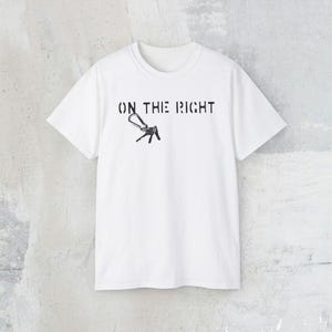 May include: White t-shirt with black text that reads "ON THE RIGHT" and a graphic of a key.