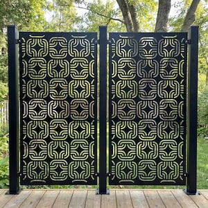 May include: Black metal privacy screen with a repeating geometric pattern. The screen is divided into two sections and is mounted on black posts. The design features interconnected square and curved shapes, creating a decorative and functional outdoor element.