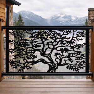 May include: Black metal railing with a cut-out tree design. The railing is installed on a wooden deck with a mountain range in the background. The tree design is intricate and detailed, with branches and leaves.