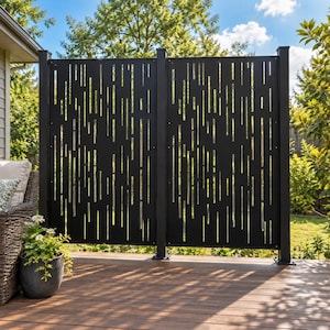 Peut inclure: Un écran de confidentialité en métal noir présentant un motif de découpes verticales de longueurs variées. L'écran se compose de deux panneaux rectangulaires montés sur trois poteaux verticaux, installés sur une terrasse en bois.