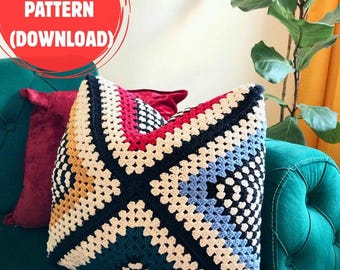 May include: A colorful, crocheted pillow with a geometric pattern in shades of blue, red, black, and cream. The pillow is on a teal couch with a red velvet pillow behind it. The image includes a red circle with the text "PDF PATTERN (DOWNLOAD)".