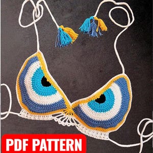 May include: Crocheted bikini top with an eye design in blue, white, and yellow. The top features adjustable straps and decorative tassels in blue and yellow. The words "PDF PATTERN" are in a red box at the bottom.