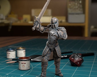 May include: A miniature metal figure of a warrior wearing armour and holding a sword. The figure is painted in a bronze colour and has intricate details. The figure is standing on a green mat with a ruler and dice.